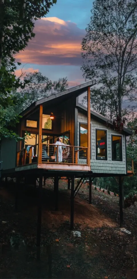 A Treetop Escapes treehouse at dusk